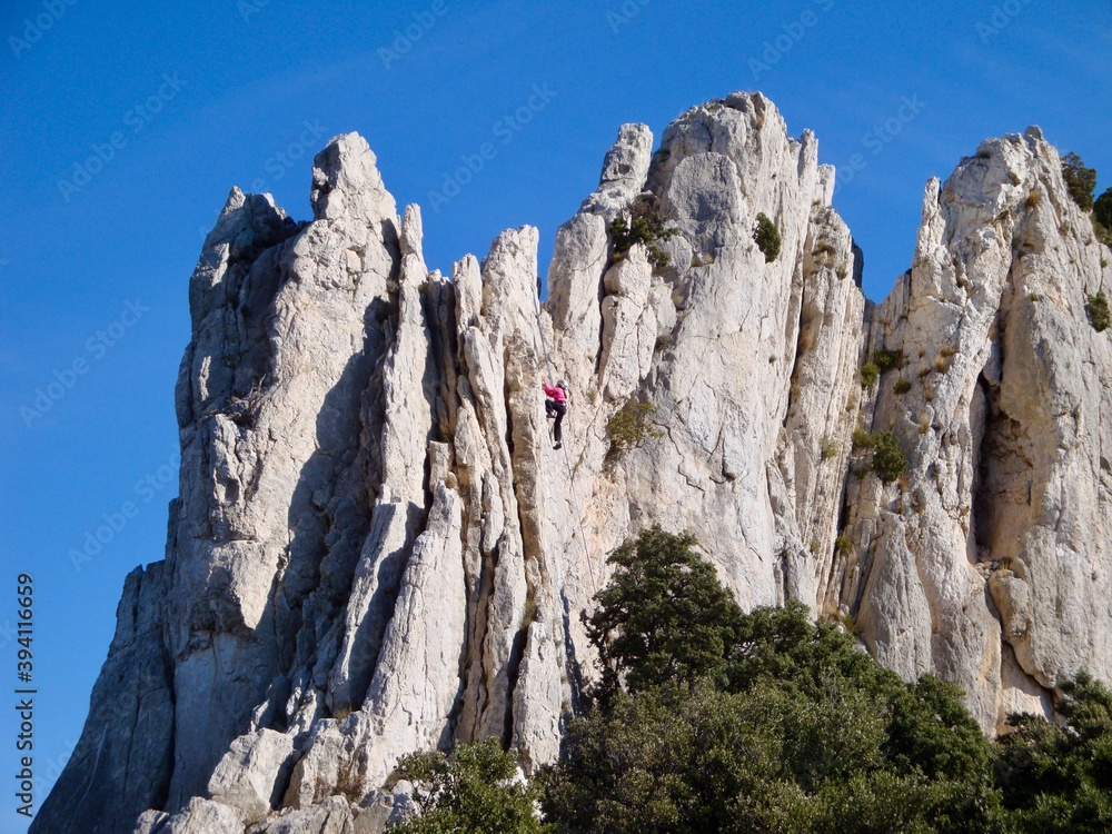 view of person rock climbing on white rock against blue sky view of person rock climbing on white rock against blue sky