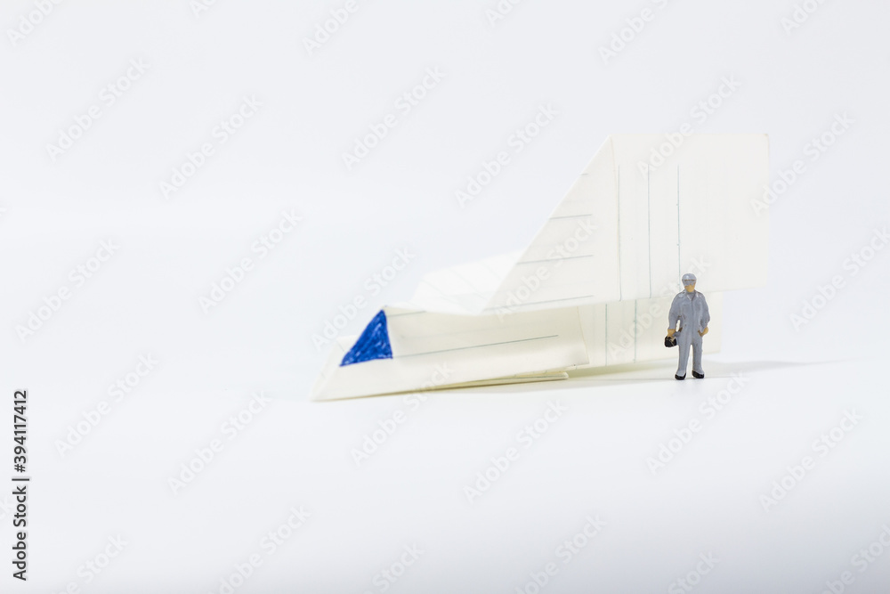 Obraz premium Miniature people : Close up engineer with paper airplane isolated on white background 