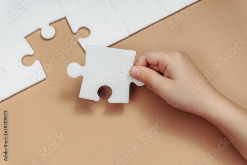 a child's hand makes the last missing piece of the puzzle. business concept