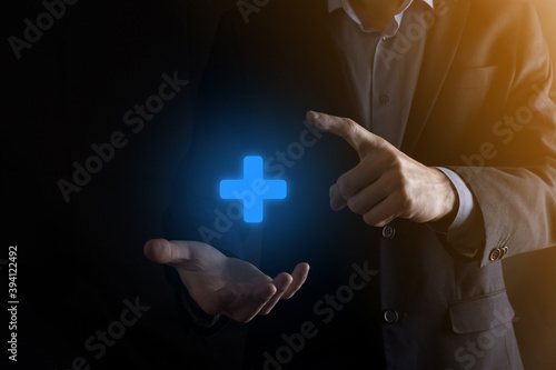 Businessman, man hold in hand offer positive thing such as profit, benefits, development, CSR represented by plus sign.The hand shows the plus sign