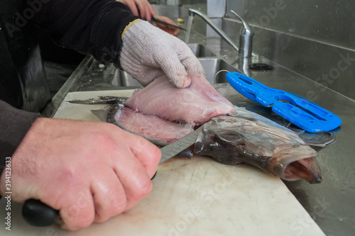 Fishmonger descaling fresh Atlantic salmon photo