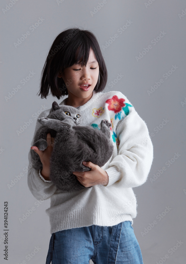 Cute asian little girl playing with cute pet cat, indoors Cute asian little girl playing with cute pet cat, indoors