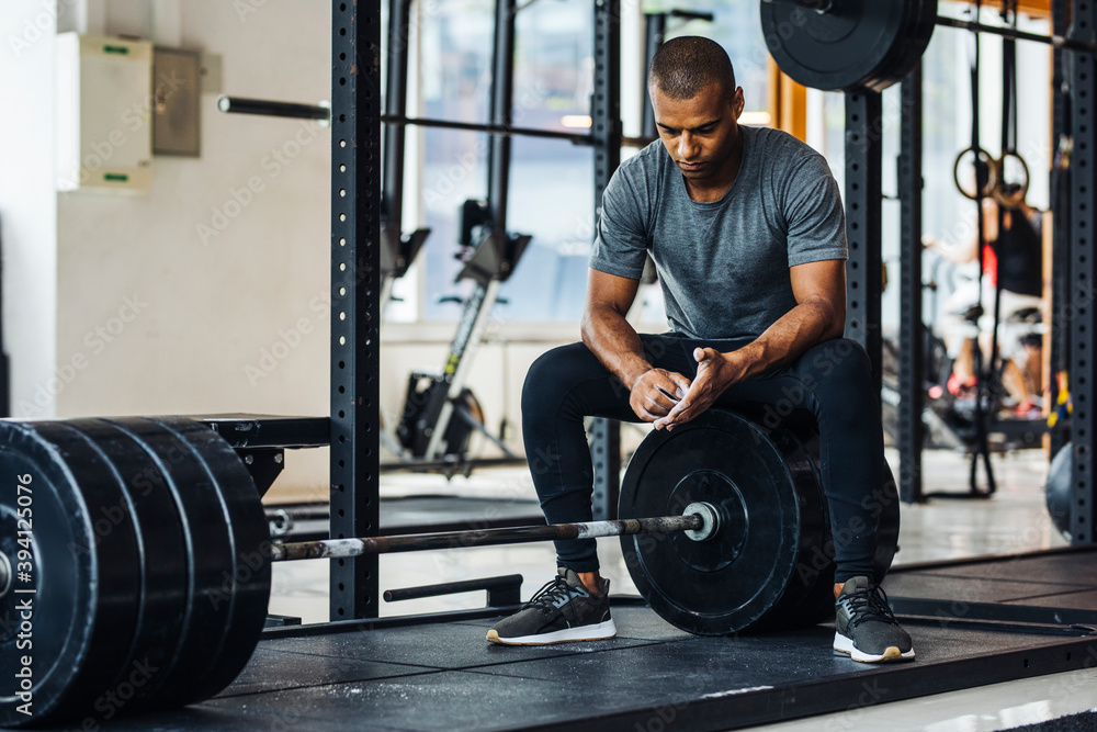 Bodybuilder Sitting on Weight at the Gym Bodybuilder Sitting on Weight at the Gym