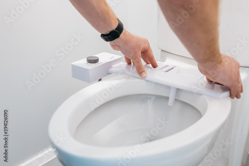 Man installing bidet due to toilet paper shortage photo