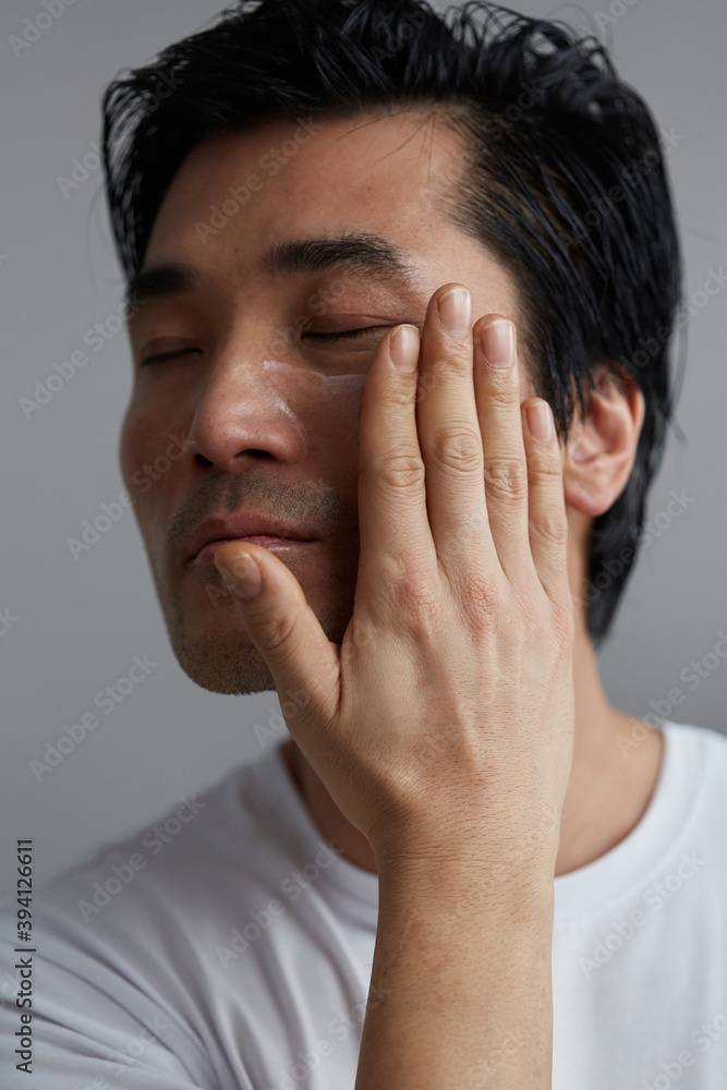 Studio portrait of man hydrating face Studio portrait of man hydrating face