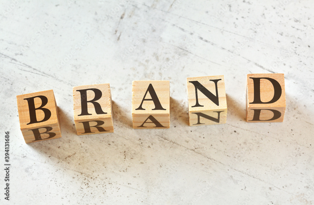 Five wooden cubes with word BRAND on white stone like board, view from above Five wooden cubes with word BRAND on white stone like board, view from above