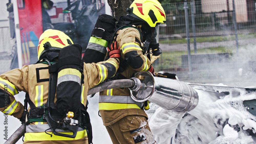 Fire drill. Firefighters extinguish fire from the nurning car using the foam. High quality photo Fire drill. Firefighters extinguish fire from the nurning car using the foam. High quality photo