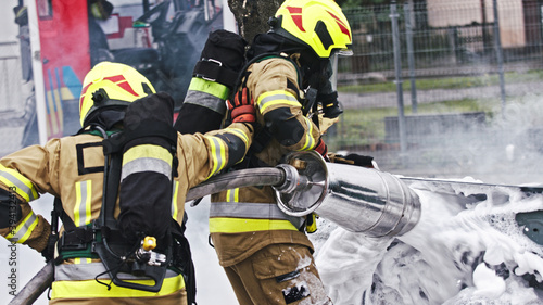  Fire drill. Firefighters extinguish fire from the nurning car using the foam. High quality photo