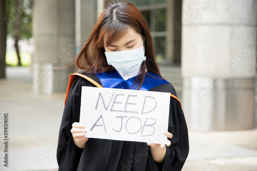 Sad, hopeless, jobless Asian college graduate student woman wearing face mask, concept of being unemployed due to job cut, employment disruption after COVID-19 pandemic led economic recession