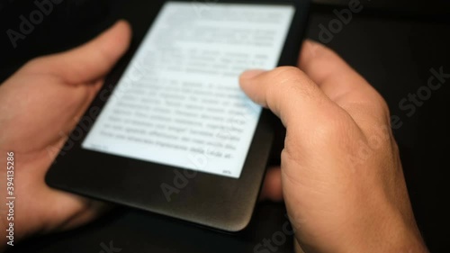 Young man using digital ebook reader at home,new book reading technology 
