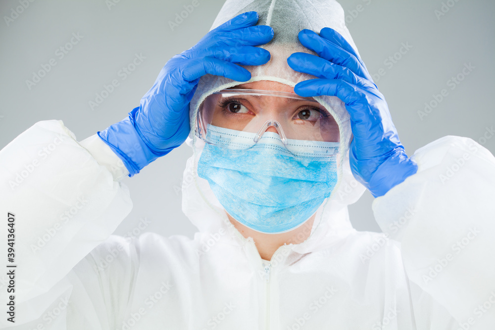 Desperate medical NHS EMS worker in white protective suit,blue