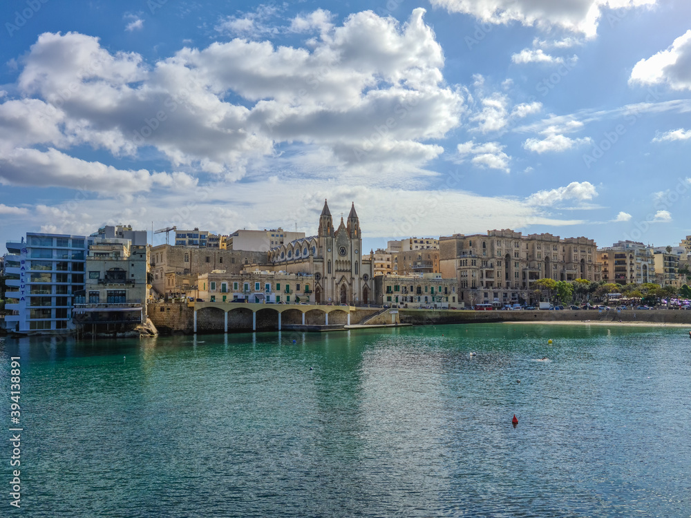Fototapeta premium The Parish Church of Our Lady of Mount Carmel and the Balluta Buildings in Balluta Bay, Malta.
