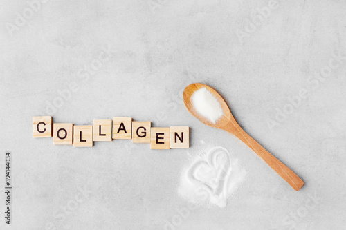 collagen powder in a spoon on a gray table, top view, heart, inscription collagen