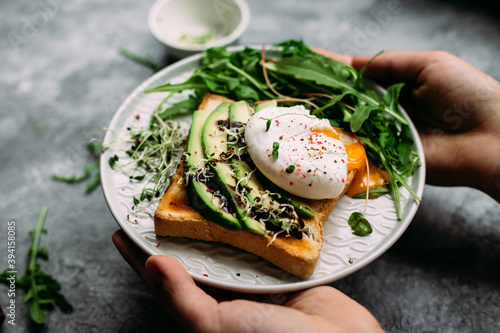 Poached egg with avocado salad, microgreen and arugula