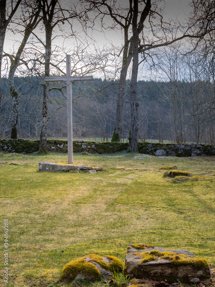 Obraz premium Wooden cross dominates the scene in a country cemetery