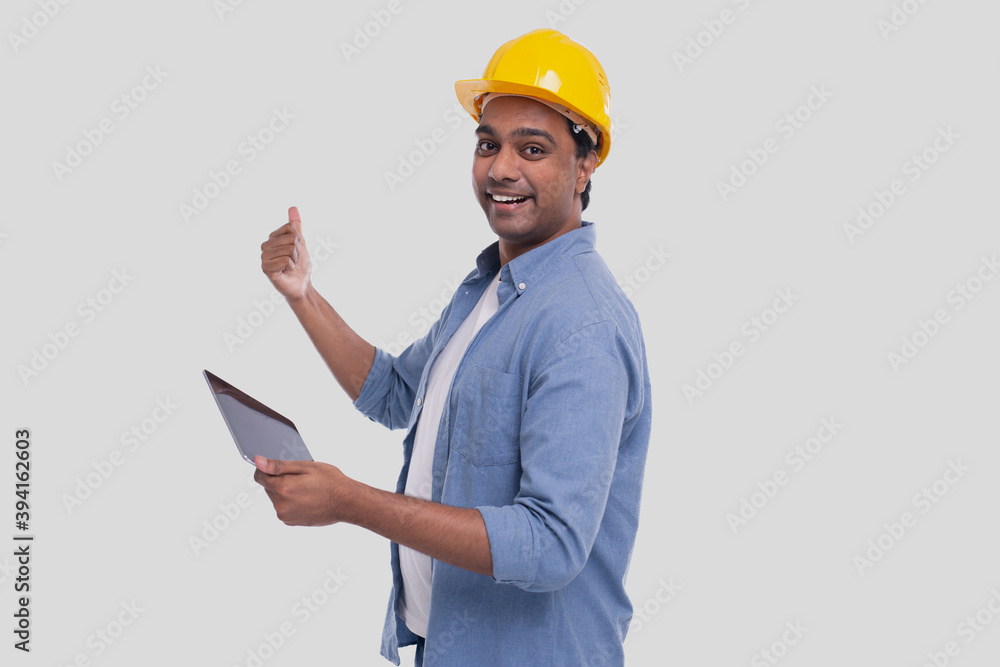 Construction Worker Holding tablet in Hands Showing Back. Man Using Tablet. Architect Holding Tablet. Yellow Hard Helmet. Worker Isolated Construction Worker Holding tablet in Hands Showing Back. Man Using Tablet. Architect Holding Tablet. Yellow Hard Helmet. Worker Isolated
