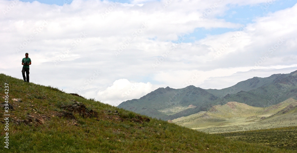 Mongolia - July 21 2019: tourist photographer taking photo of beautiful landscape. Consept of healthy active lifestyle, hiking, traveling. Photo with copy space.
