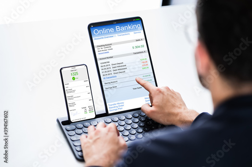 Young Businessman Looking At Invoice While Doing Online Banking