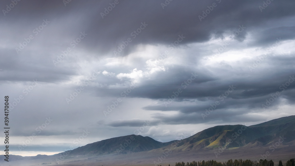 Fototapeta premium sky with evening clouds over mountain ridge in fall