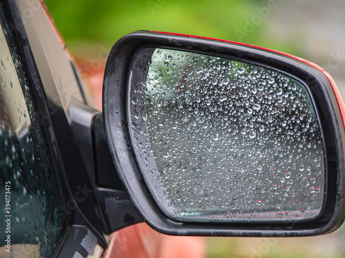 car side rear view mirror with rain drops