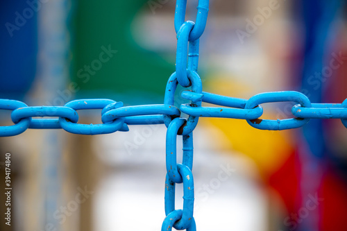 Crossed blue metal chain on blurred background