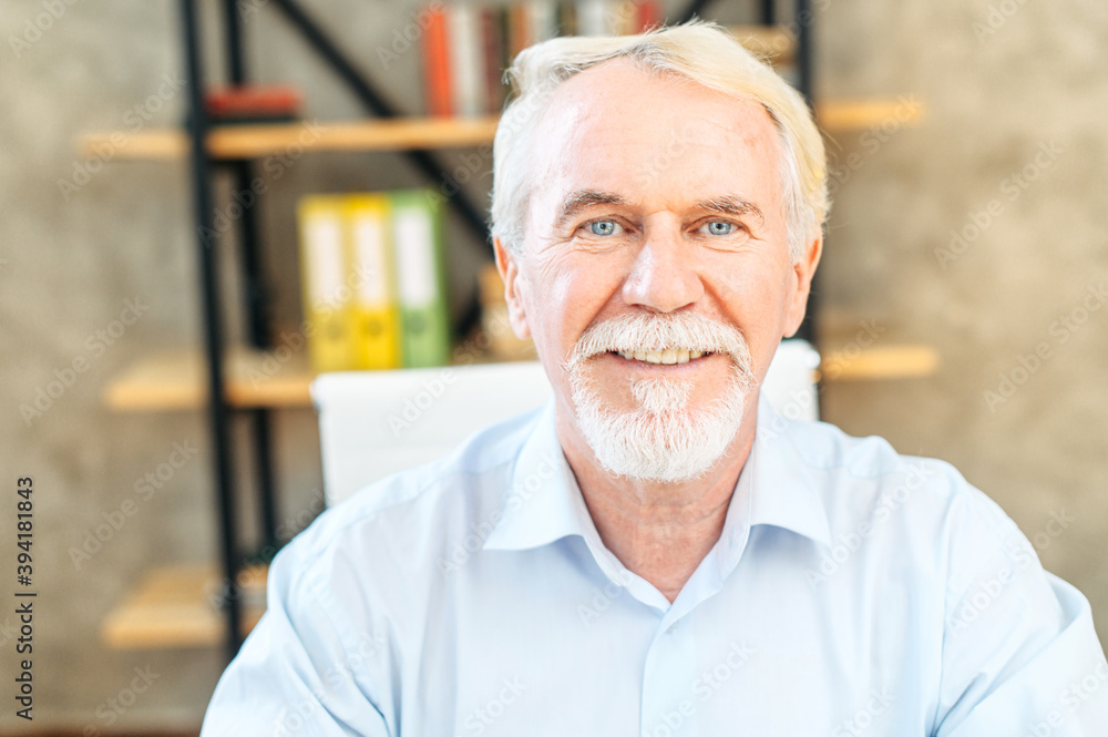 Video call with a senior businessman. A senior grey haired man in smart casual wear looks at webcam with a pleasure smile Video call with a senior businessman. A senior grey haired man in smart casual wear looks at webcam with a pleasure smile