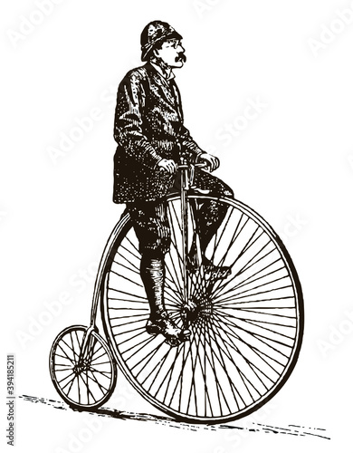 Cyclist from the 19th century riding antique high wheel bicycle © M