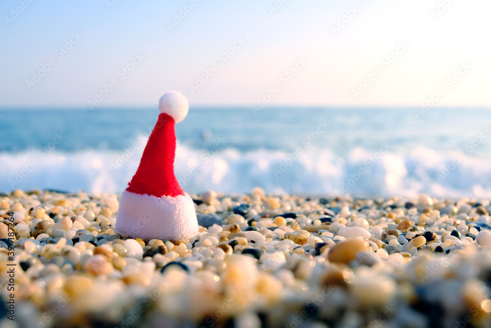 Santa claus hat on the seaside. Rest during a pandemic. Quarantine during the holidays. Travel agency crisis