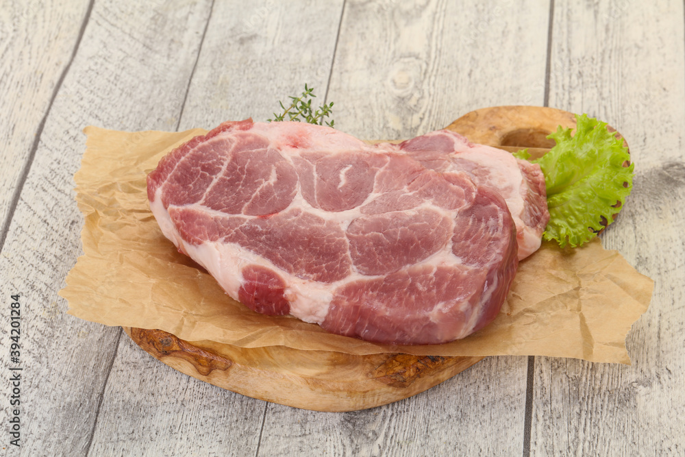 Fototapeta premium Raw pork steak over wooden board