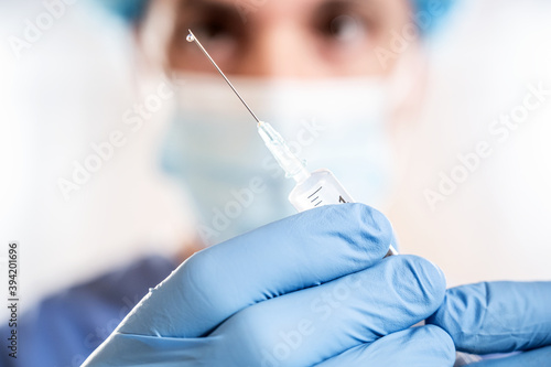 Doctor man holding a syringe with Coronavirus vaccine in his hands. Covid-19 Vaccination
