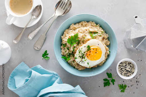 Savoury oatmeal with fried eggs sunny side up for breakfast