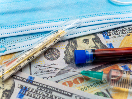 srynge medical masks and blood sample over hundred dollars bills healthcare medical concept photo