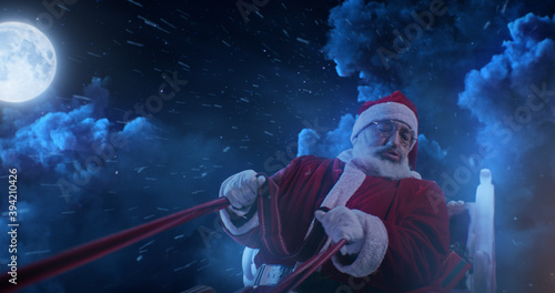 Santa Claus riding sleigh in night sky