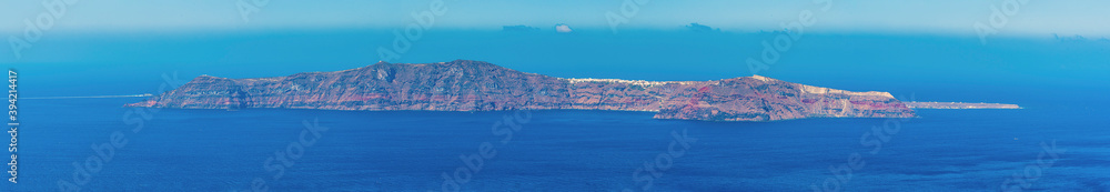 A panorama view of the island of Thirasia from the village of Imerovigli, Santorini in summertime