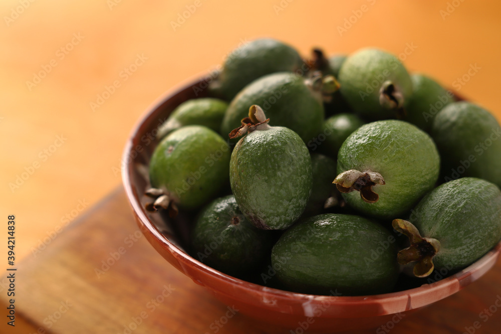 feijoa in a bowl on a wooden background. Close-up. feijoa in a bowl on a wooden background. Close-up.