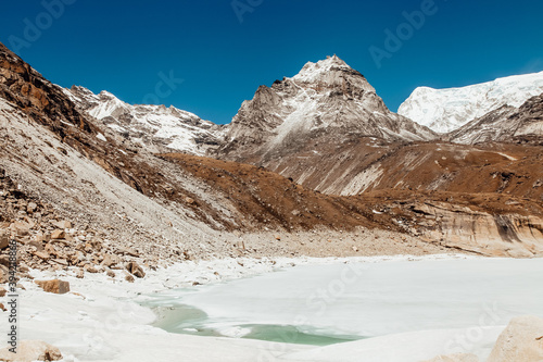 Amazing blue Gokio lake under ice and snow, Nepal, Himalayas