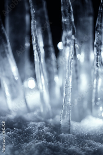 crystal icicles in white snow at dark night