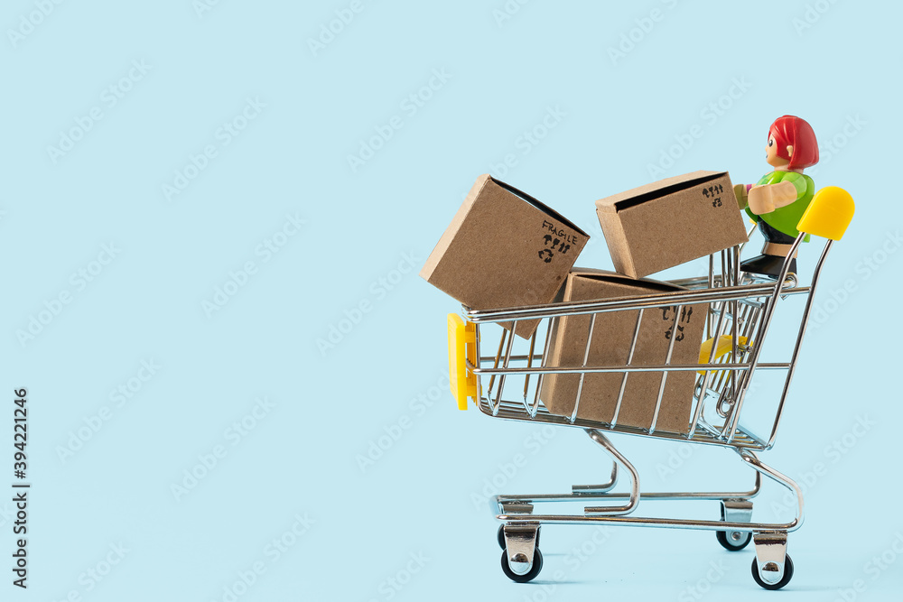 Toy shopping cart with boxes on blue background