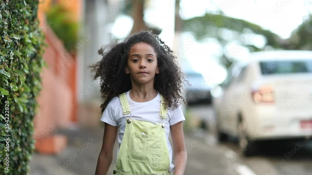 Little girl walking outside in city sidewalk, cute mixed race child outdoors Little girl walking outside in city sidewalk, cute mixed race child outdoors