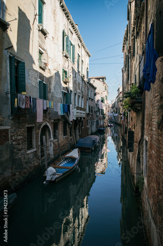 Narrow canals with bridge of Venice  Italy. Tourist sailing on an romantic gondola with gondolier boat. Exterior of medieval buildings.