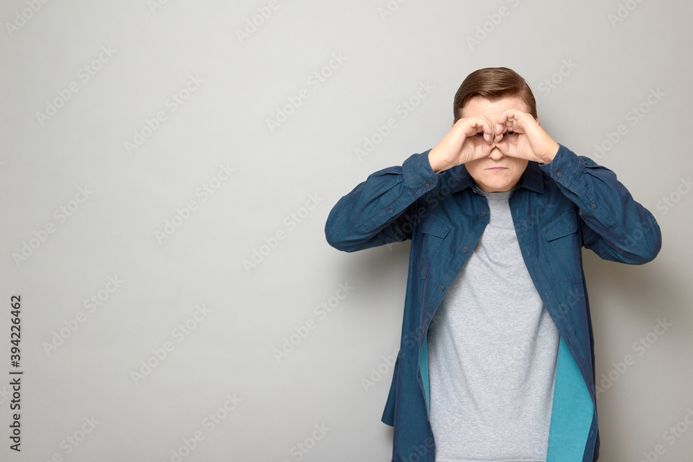 Portrait of serious man making binoculars with hands and looking afar Portrait of serious man making binoculars with hands and looking afar