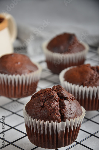 Chocolate muffins in a white paper capsule, standing on the grate.