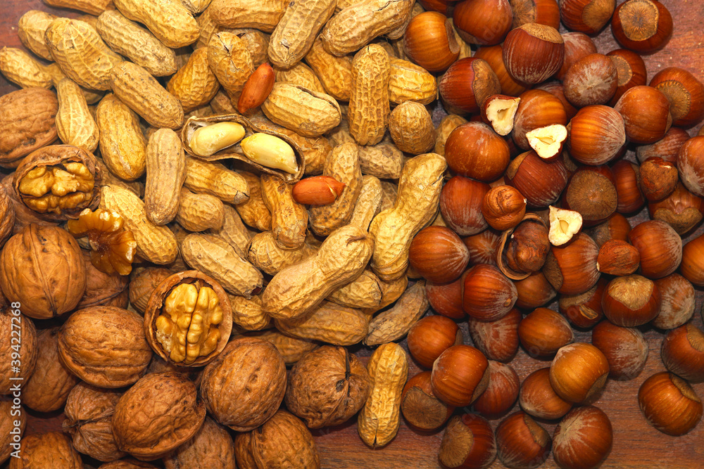 Walnuts, hazelnuts and peanuts on dark table