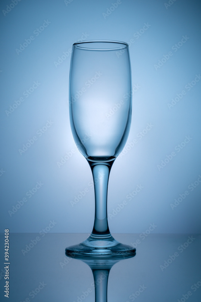 Empty champagne glass on blue background