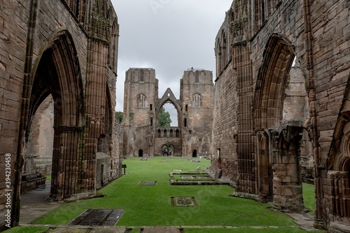 The courtyard of Elgin Cathedral with tourists and typical Scottish cloudy weather