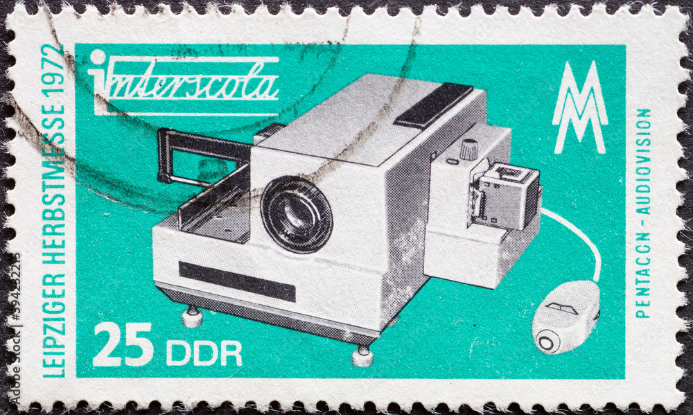 Obraz premium GERMANY, DDR - CIRCA 1972: a postage stamp from Germany, GDR showing a slide projector. Text: Leipzig Autumn Fair 1972