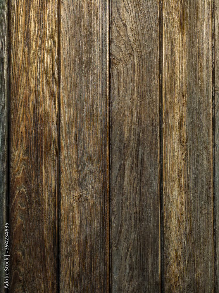 Naklejka premium A background of dark wood planks tightly adjacent to each other. Wooden boards with a clearly visible wood texture.