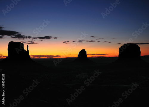 View To The East Mitten Butte, Merrick Butte And West Mitten Butte In The Monument Valley Arizona In The Morning Before Sunrise On A Sunny Summer Day With A Clear Blue Sky And A Few Clouds
