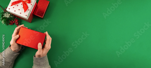 Man holding red gift box festive atmosphere photo banner with negative space, green background