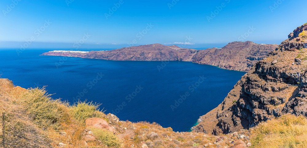 A view of Santorini's caldera arcing around towards the north of the island in summertime